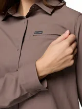 Camisa de trekking Columbia de manga larga, color marrón, con cuello clásico, cierre frontal de botones y bolsillo en el pecho con logo de la marca. Diseño técnico con tecnología Omni-Shade y Omni-Wick.