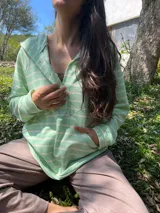 Canguro verde agua a rayas horizontales blancas, de corte amplio, con escote con broches para facilitar la lactancia, bolsillo al frente y puños en mangas y bajo.