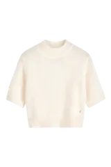 Top de punto de textura suave y esponjosa, color crudo, con cuello alto y mangas cortas. Presenta un corte cropped que llega a la cintura.