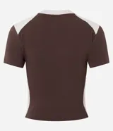 Remera de algodón con corte ajustado, manga corta y cuello redondo. Presenta un diseño bicolor en marrón y crema con estampado gráfico estilo college y lettering frontal.