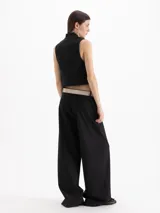 Pantalón de vestir tiro alto color celeste, de corte wide leg y largo hasta el suelo, con bolsillos delanteros decorados con volados tableados y bolsillos ojal en la espalda.