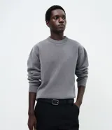 Suéter masculino de cuello redondo y manga larga, confeccionado en tejido fleece con textura suave. Presenta puños y ruedo acanalados, con un diseño minimalista y sin estampados.