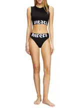 Top blanco de algodón con logo de la marca en la banda inferior.