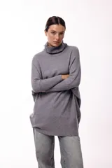 Sweater de punto color gris, con cuello polera amplio y diseño oversize de silueta fluida y caída liviana.