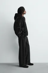 Cazadora bomber reversible de corte relajado confeccionada en tejido técnico. Presenta capucha con interior de pelo sintético, cierre frontal con cremallera de doble dirección, bolsillos laterales y puños y bajo con acabado en rib elástico.