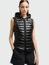 Chaqueta puffer negra con capucha, cierre frontal con cremallera, bolsillos laterales con cremallera y logo de la marca en el pecho.