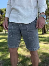 Bermuda de jean gris claro con efecto acid wash, bolsillos delanteros aplicados y costuras destacadas.