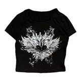 Remera tipo baby tee de corte ajustado, color negro, con estampado frontal en blanco de un corazón con alas y elementos urbanos.