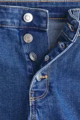 Jean de tiro alto con corte acampanado desde la rodilla, confeccionado en denim con leve stretch. Presenta cierre frontal de botones y diseño clásico de cinco bolsillos.