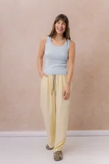 Pantalón amarillo de corte amplio y pierna recta, confeccionado en tela liviana con caída fluida. Cuenta con cintura elastizada, cordón regulable en contraste y bolsillos laterales.