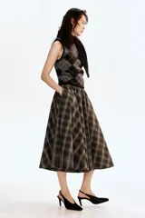 Top sin mangas de punto suave con mezcla de mohair y lana, con estampado de rombos en tonos negro y gris. Presenta un cuello tipo bufanda integrado con abertura para cruzar y remate acanalado en el bajo.