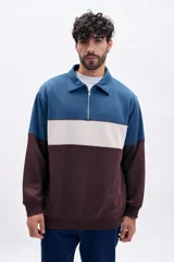 Buzo deportivo de hombre con medio cierre, cuello polo y diseño de bloques de color en azul, beige y marrón.
