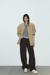 Zapatillas deportivas de cuero color beige y blanco, con suela marrón de goma y cierre con cordones.