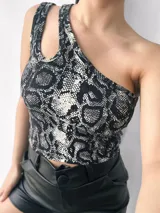 Top negro brillante de un solo hombro con abertura en el hombro izquierdo.