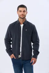 Camisa de manga larga confeccionada en pana fina de algodón, con cuello camisero, cierre frontal de botones y un bolsillo aplicado en el pecho.