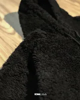 Canguro color marrón claro, con capucha y cordones ajustables, forrado con polar y reguladores en la cintura para ajustarlo.