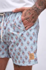 Short de baño celeste con rayas verticales blancas y estampado de flores blancas y azules.