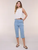 Capri de denim blanco con pretina ancha elastizada, tiro alto, bolsillos simulados al frente y bolsillos funcionales en la parte posterior, con pequeños tajos laterales en el bajo.