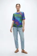 Remera con estampado abstracto en tonos verdes, azules y naranjas.