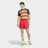 Remera Adidas Originals de corte ajustado con diseño de rayas horizontales en colores rojo, amarillo y verde. Presenta mangas cortas negras con las icónicas tres tiras blancas en los hombros, cuello redondo negro, logo del trébol bordado en el pecho y la inscripción 'Bob' en tipografía cursiva.