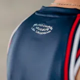 Musculosa de básquet Umbro del Club Nacional de Football, modelo alternativa. Diseño en color azul marino con estampado sutil en toda la prenda, cuello y sisas con detalles en blanco y rojo. Incluye logo de Umbro y escudo del club en el pecho.