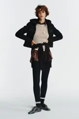 Chaqueta acolchada negra con cuello subido y capucha ajustable con cordones elásticos y stopper. Mangas largas combinadas en tejido efecto neopreno. Bolsillos laterales y cierre frontal con cremallera termosellada.