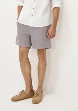 Short de baño blanco con estampado de hojas negras, cintura elástica y bolsillos laterales.