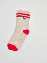 Medias marineras color beige con puntera y talón rojos, dos líneas horizontales rojas en la parte superior y una letra M verde.