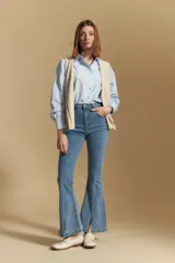 Jean oxford de tiro alto confeccionado en denim con spandex, de color gris oscuro lavado. Presenta un corte ajustado en la parte superior que se ensancha hacia el ruedo, el cual incluye aberturas frontales.