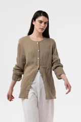 Camisa de lino color beige, de calce relajado, cuello redondo y cierre frontal de botones.