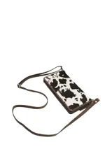 Billetera Rockford de cuero natural con pelo de vaca, diseño con estampa animal print de vaca en color blanco y negro, con detalles en marrón y cierre perimetral.