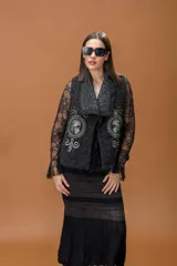 Falda midi de tejido de punto en color negro, con diseño de franjas horizontales que combinan diferentes texturas y sutiles detalles de lurex. La parte inferior presenta un tejido más liviano y fluido.