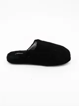 Pantuflas de estar por casa color negro, confeccionadas en tejido de pana con textura acanalada y suela plana.