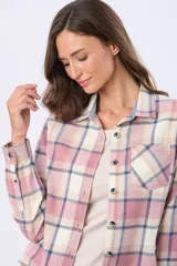 Camisa de viyela a cuadros en tonos rosado, beige y azul. Presenta cuello camisero, cierre frontal con botones, mangas largas con puños abotonados y un bolsillo frontal en el pecho.
