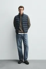 Chaleco acolchado de hombre color negro, con diseño puffer, cuello alto y cierre frontal con cremallera.