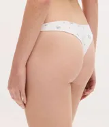 Kit de dos bombachas tipo bikini confeccionadas en algodón con elastano. Una prenda es de color celeste liso y la otra presenta un estampado floral delicado sobre fondo blanco. Ambas cuentan con un pequeño lazo decorativo en la cintura.