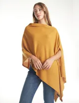 Poncho tejido de punto con diseño asimétrico y aberturas laterales para los brazos.