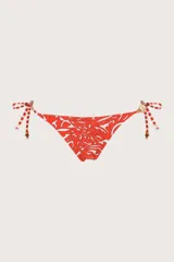 Calzón de bikini reversible con estampado floral en tonos naranja y blanco, con tiras laterales ajustables y cuentas decorativas.
