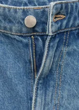 Pantalón de jean estilo balloon, de tiro medio y corte holgado, con diseño de cinco bolsillos, cierre de botón y cremallera.
