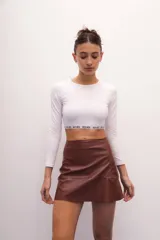 Minifalda marrón de ecocuero, de tiro medio y corte evasé.