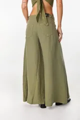 Pantalón de lino verde militar, de tiro alto y corte amplio con botamanga ancha. Cuenta con bolsillos delanteros aplicados y cierre frontal con botón y bragueta.