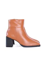 Botines de cuero color caramelo, con caña media, cierre lateral y puntera cuadrada. Tienen un tacón bloque negro de aproximadamente 7 cm.