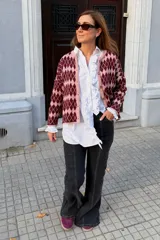 Saco tejido con diseño de rombos en tonos bordó y rosado, con cierre frontal de botones y cuello redondo.