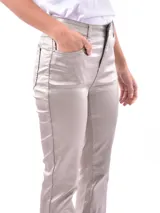Pantalón de corte oxford con acabado metalizado en tono dorado. Presenta diseño de cinco bolsillos, cierre frontal con botón y cremallera, y pernera ligeramente acampanada.