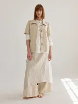 Chaqueta de lino color beige, con cuello camisero, manga corta y cierre frontal con botones de madera.