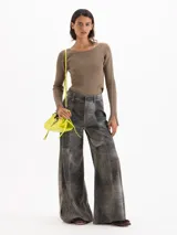 Pantalon de cuero ovino gris con diseño de pata ancha y recortes geométricos a la altura de las rodillas.