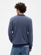 Buzo de tejido de punto con cuello polo y cierre frontal de dos botones. Presenta un diseño bicolor con cuerpo en tono beige y detalles en cuello y puños en color marrón oscuro.