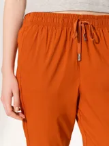 Pantalón babucha color borgoña, confeccionado en algodón liviano. Presenta cintura elastizada con cordón ajustable, bolsillos laterales y botamangas levemente entalladas.