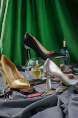 Zapato de tacón plateado, con punta fina y taco con forma de esfera.