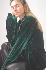 Campera verde inglés de terciopelo con cierre dorado y cuello alto.